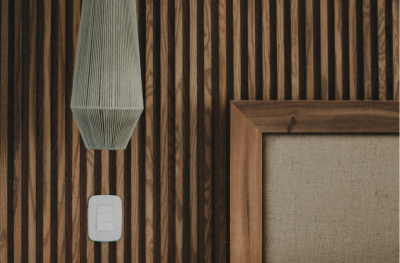 Wooden headboard and hanging pendant light in a modern Tulum bedroom.