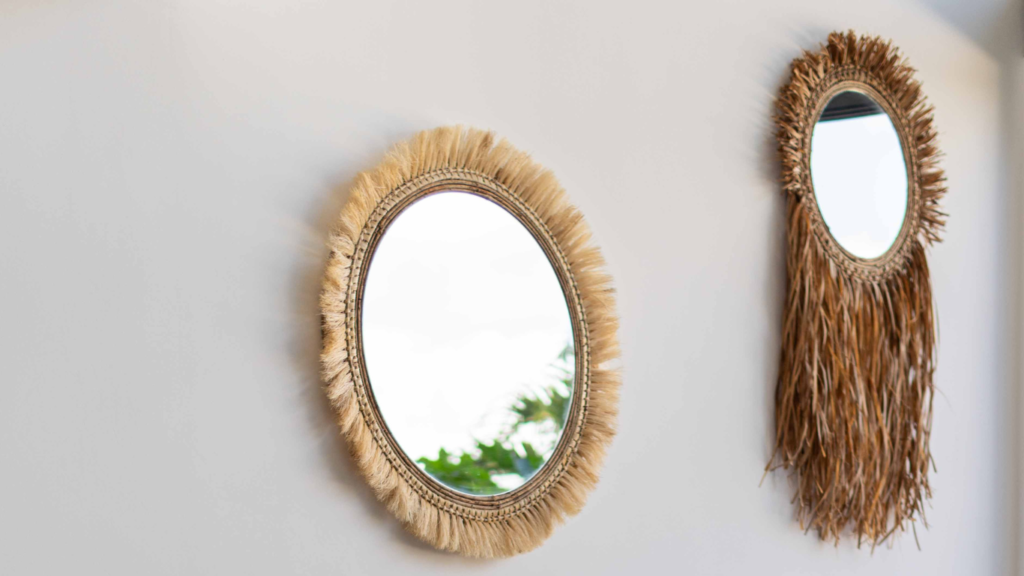 "Two round boho mirrors with natural fringe hanging on a wall, ideal for Tulum interior design."